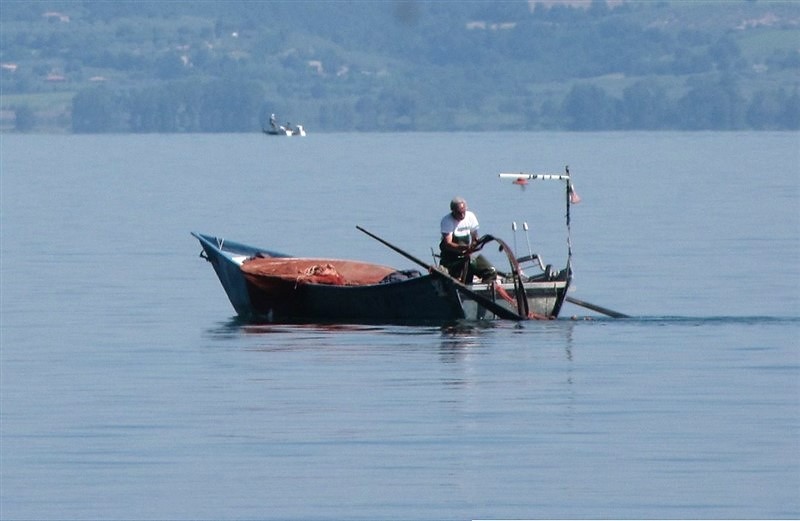 Un pescatore con la sua barca a Marta sul lago di Bolsena